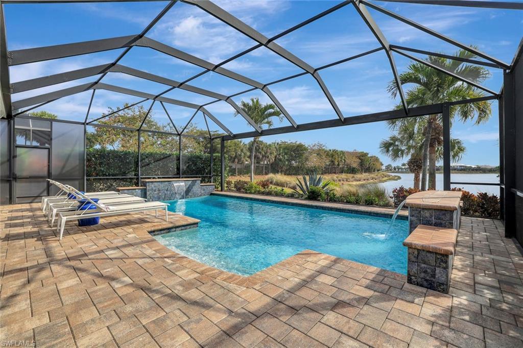 4905 Andros Drive Naples, FL 34113 - Photo 8 of 45 Swimming pool featuring dual waterfalls, a patio, and a water view