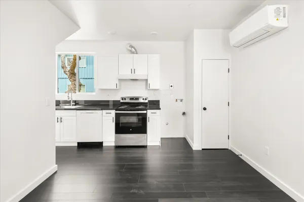 a kitchen with wooden floors and white stainless steel appliances