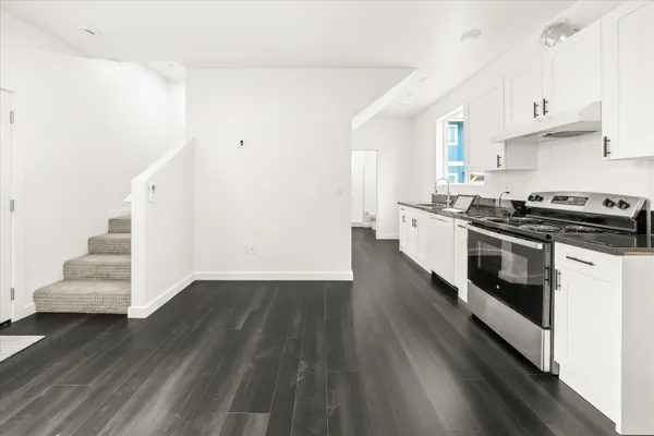 a kitchen with granite countertop a stove and a wooden floors