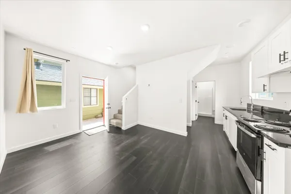 a view of a kitchen with a stove wooden floor and a window