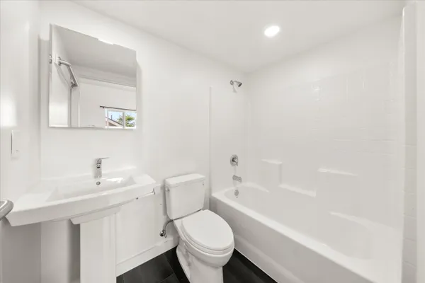 a white toilet sitting next to a bathroom sink