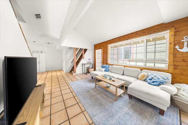 a living room with furniture and a floor to ceiling window