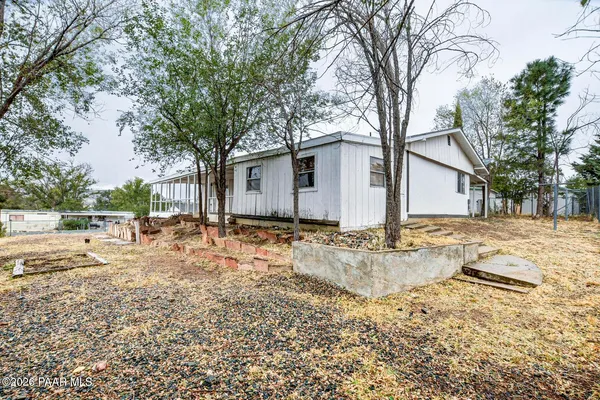 a kitchen with stainless steel appliances granite countertop a stove a sink dishwasher and white cabinets with wooden floor