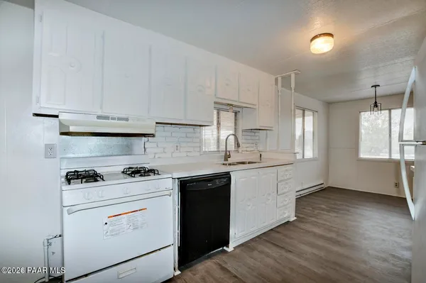 an empty room with wooden floor and entrance