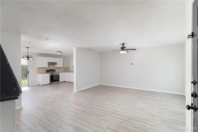 wooden floor in an empty room with a kitchen