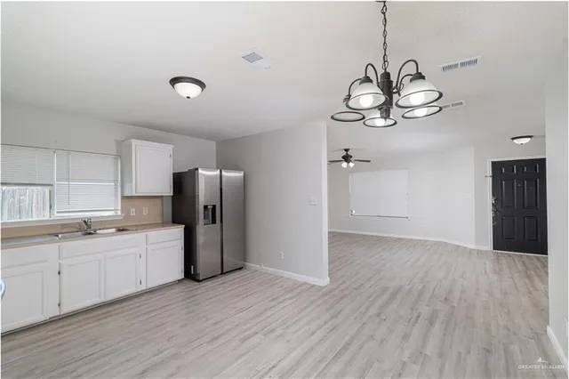 a view of a kitchen with a sink wooden cabinet and stainless steel appliances