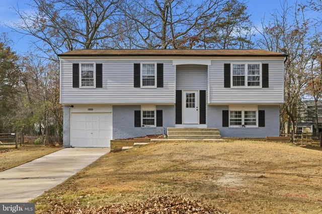 a front view of a house with yard and trees