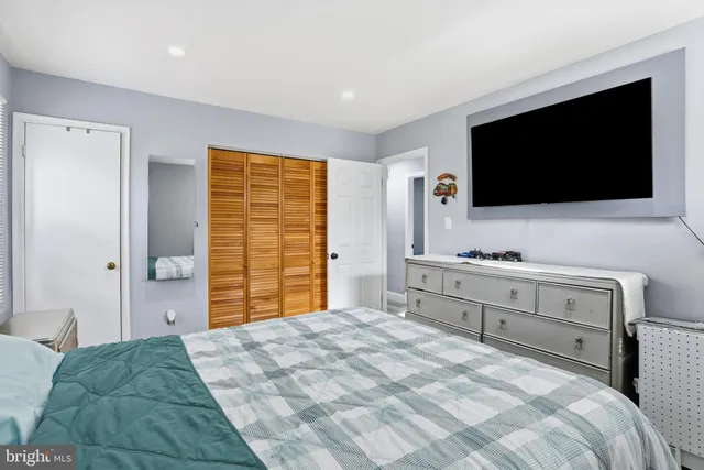 a bedroom with a bed and a flat screen tv