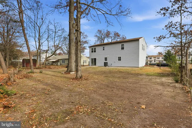 a view of a house with a large tree and a yard