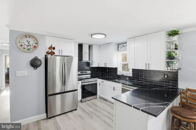 a kitchen with stainless steel appliances granite countertop a refrigerator and a stove top oven
