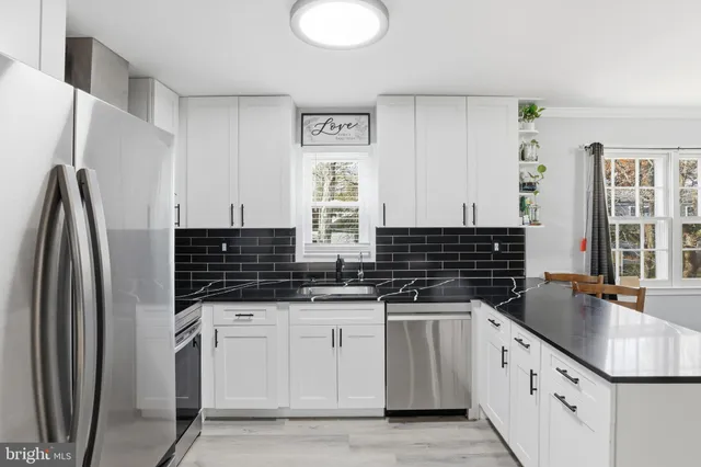 a kitchen with granite countertop a sink stove and refrigerator