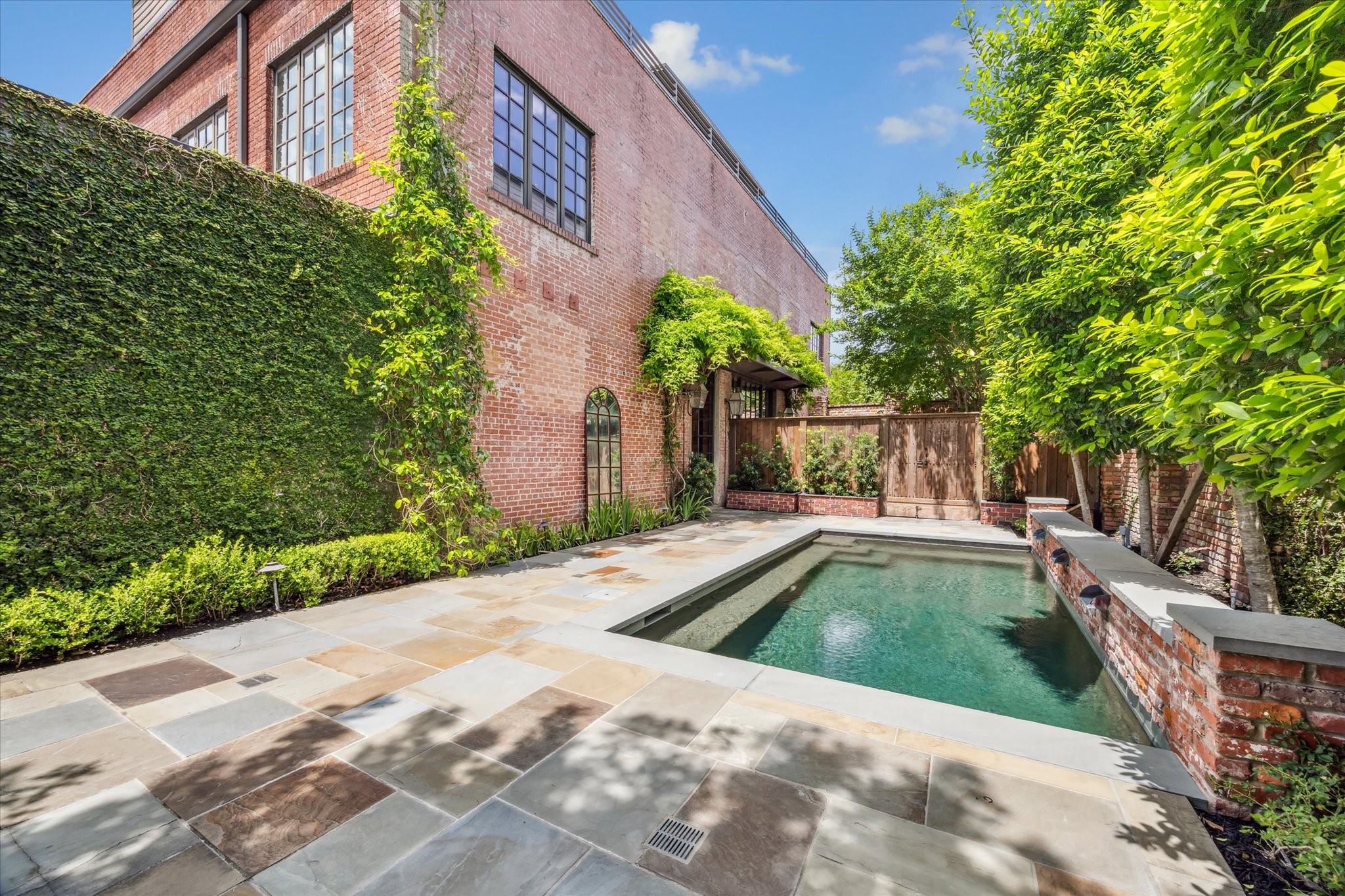 808 Coronado Street Houston, TX 77009 - Photo 49 of 50 Unit 2, Alternate angle of private pool area with brick wall accents and greenery.