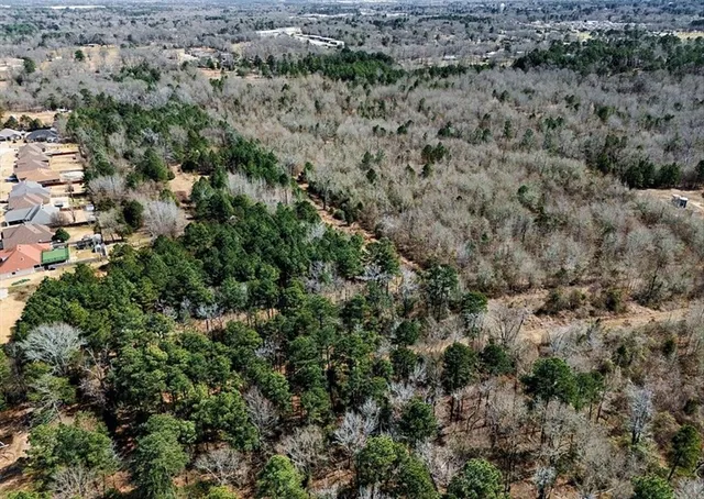 an aerial view of house with yard and trees around