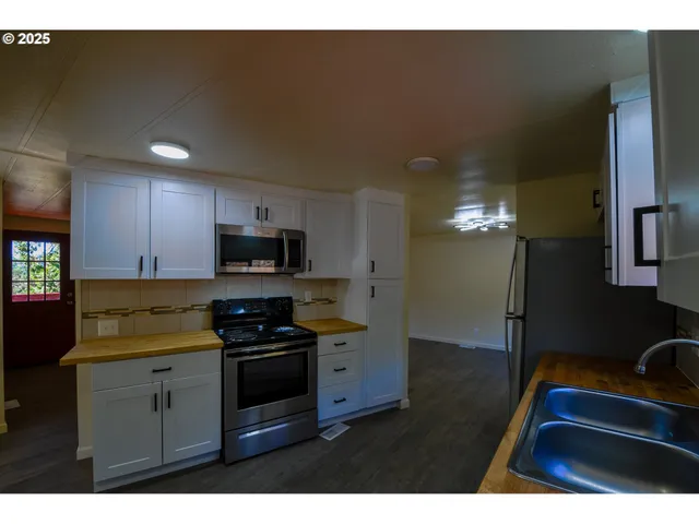 a kitchen with granite countertop stainless steel appliances and wooden cabinets