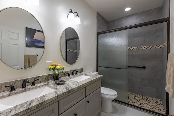 a bathroom with a granite countertop double vanity sinks and a mirror