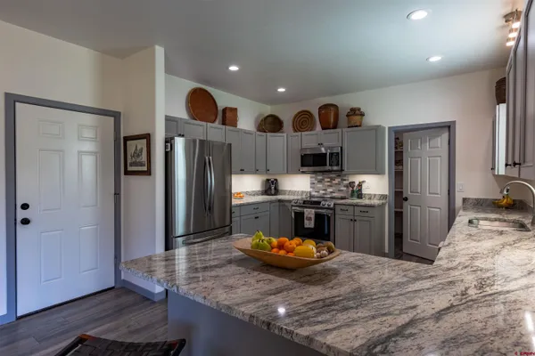 a kitchen with stainless steel appliances granite countertop a refrigerator oven stove a sink and dishwasher