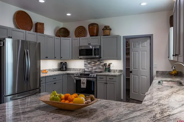 a kitchen with stainless steel appliances granite countertop a stove refrigerator and cabinets