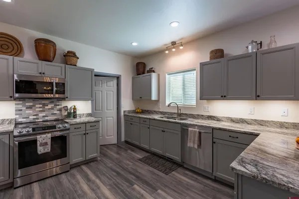 a kitchen with stainless steel appliances granite countertop wooden cabinets stove top oven and sink