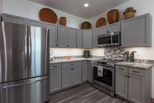 a kitchen with stainless steel appliances granite countertop a refrigerator sink and stove