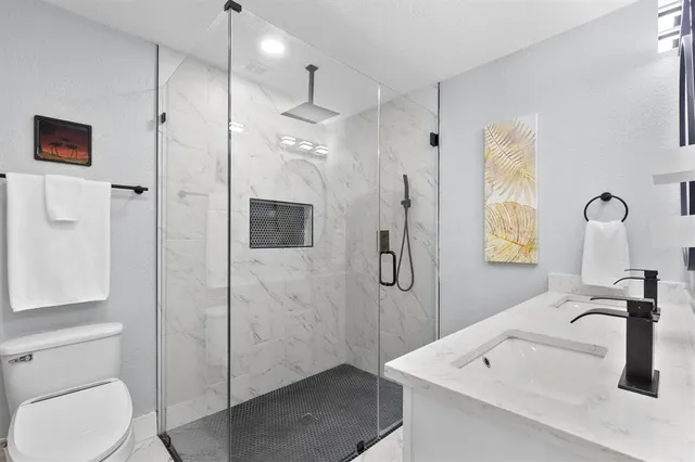 a bathroom with a sink a toilet and shower