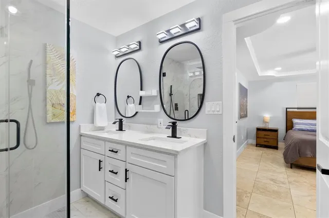 a bathroom with a granite countertop sink mirror and a shower