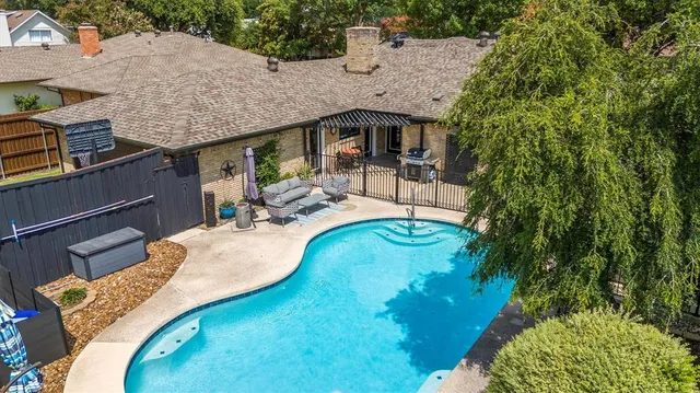 an aerial view of a house with swimming pool and patio