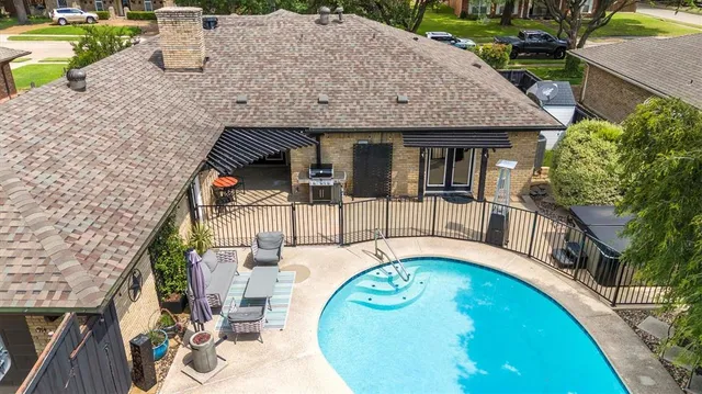 an aerial view of a house with swimming pool and patio