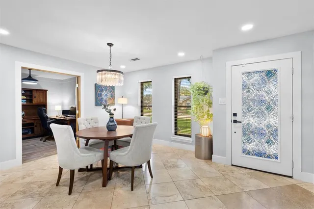 a dining room with furniture a chandelier and wooden floor