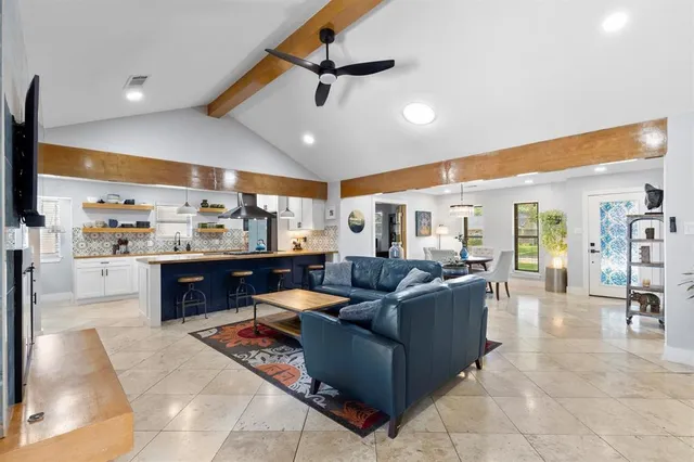a living room with lots of furniture and view of kitchen
