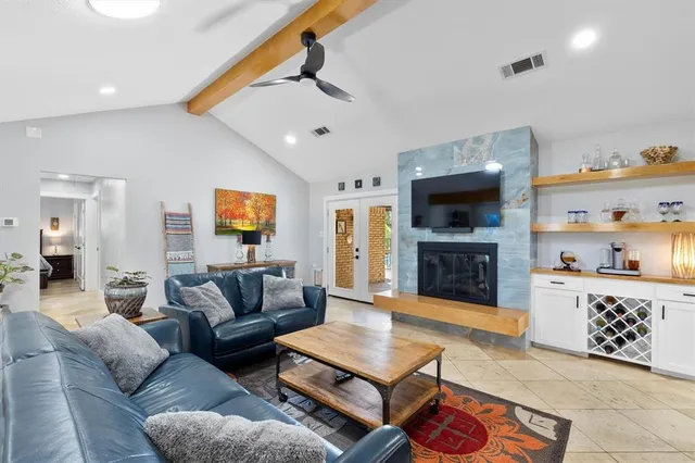 a living room with furniture a flat screen tv and a fireplace