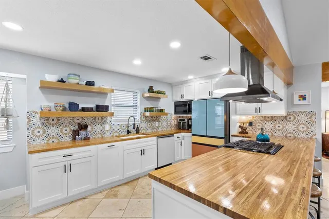 a kitchen with stainless steel appliances kitchen island granite countertop a refrigerator and dishwasher
