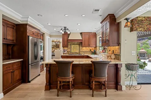 a large kitchen with stainless steel appliances granite countertop a stove and a sink
