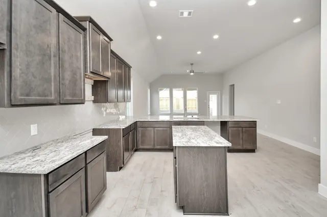 a kitchen with granite countertop a stove a sink and a microwave