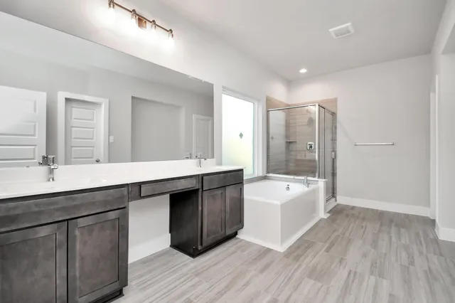 a spacious bathroom with a granite countertop sink a toilet a bathtub and shower