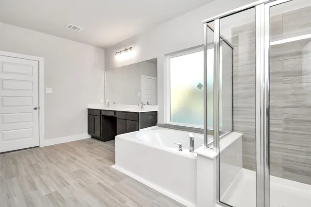 a bathroom with a tub sink and mirror