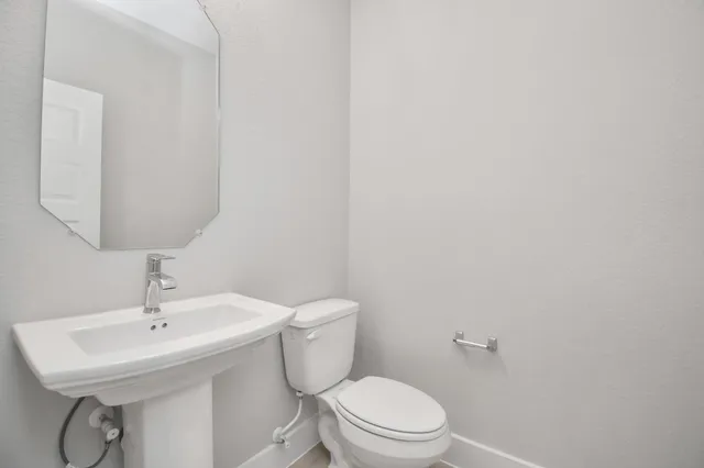 a bathroom with a toilet a sink and mirror
