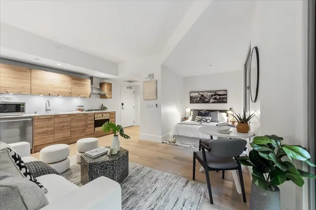 a living room with furniture kitchen view and a large window