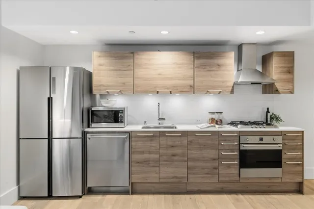 a kitchen with stainless steel appliances granite countertop a stove a refrigerator and a sink