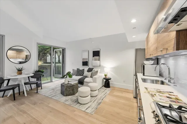a living room with furniture a window and a dining table with wooden floor