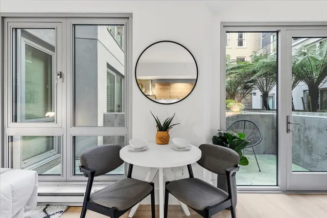 a dining room with furniture and a potted plant