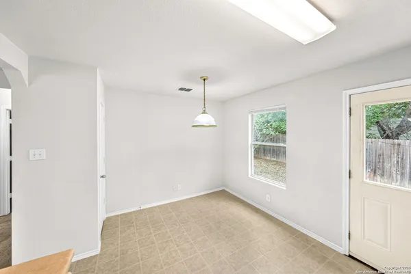 an empty room with windows and ceiling fan
