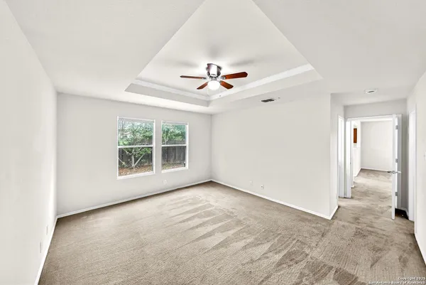 an empty room with a window and a ceiling fan