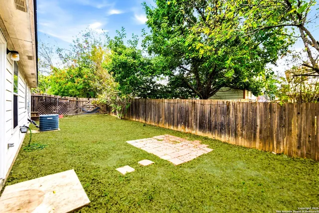 a backyard of a house with table and chairs