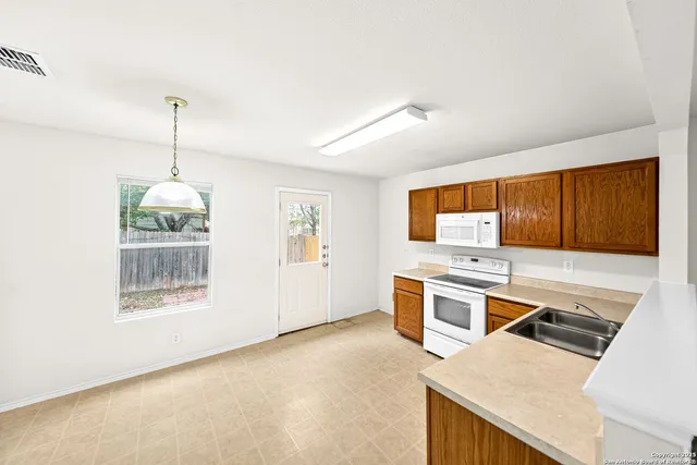 a kitchen with a white stove top oven and sink