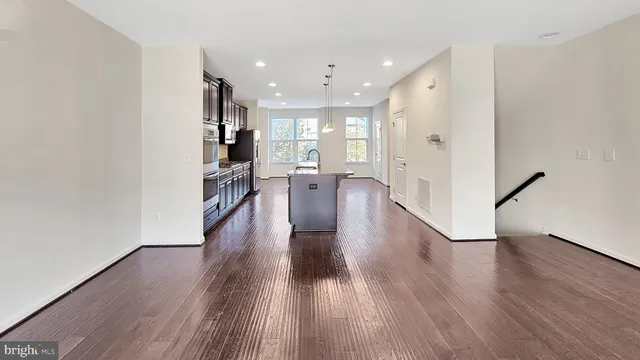 a view of a large kitchen with wooden floor and a window