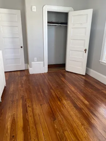 an empty room with wooden floor and closet