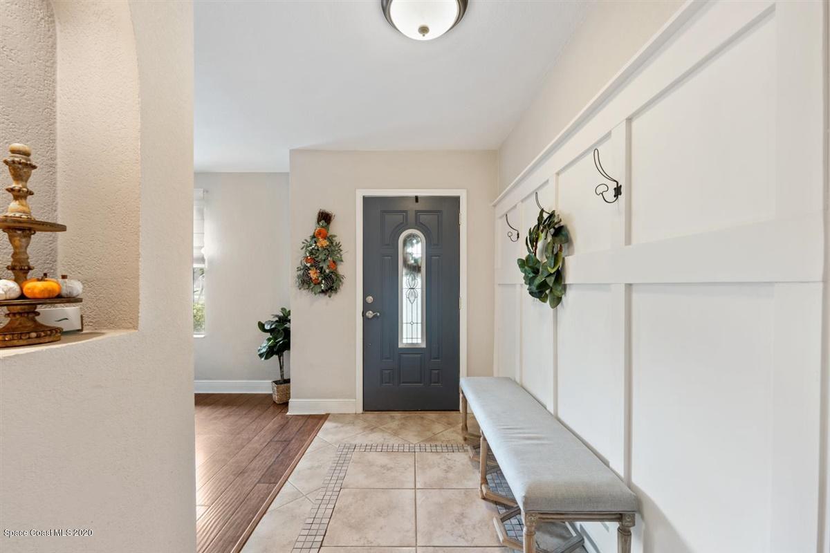 108 Neptune Court Indialantic, FL 32903 - Photo 13 of 33 a view of a hallway to a livingroom with wooden floor and furniture