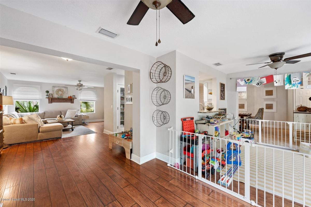 108 Neptune Court Indialantic, FL 32903 - Photo 23 of 33 a living room with lots of furniture and a book shelf