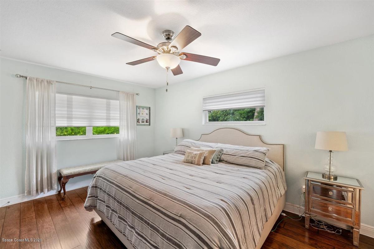 108 Neptune Court Indialantic, FL 32903 - Photo 24 of 33 a bedroom with a bed and a chandelier
