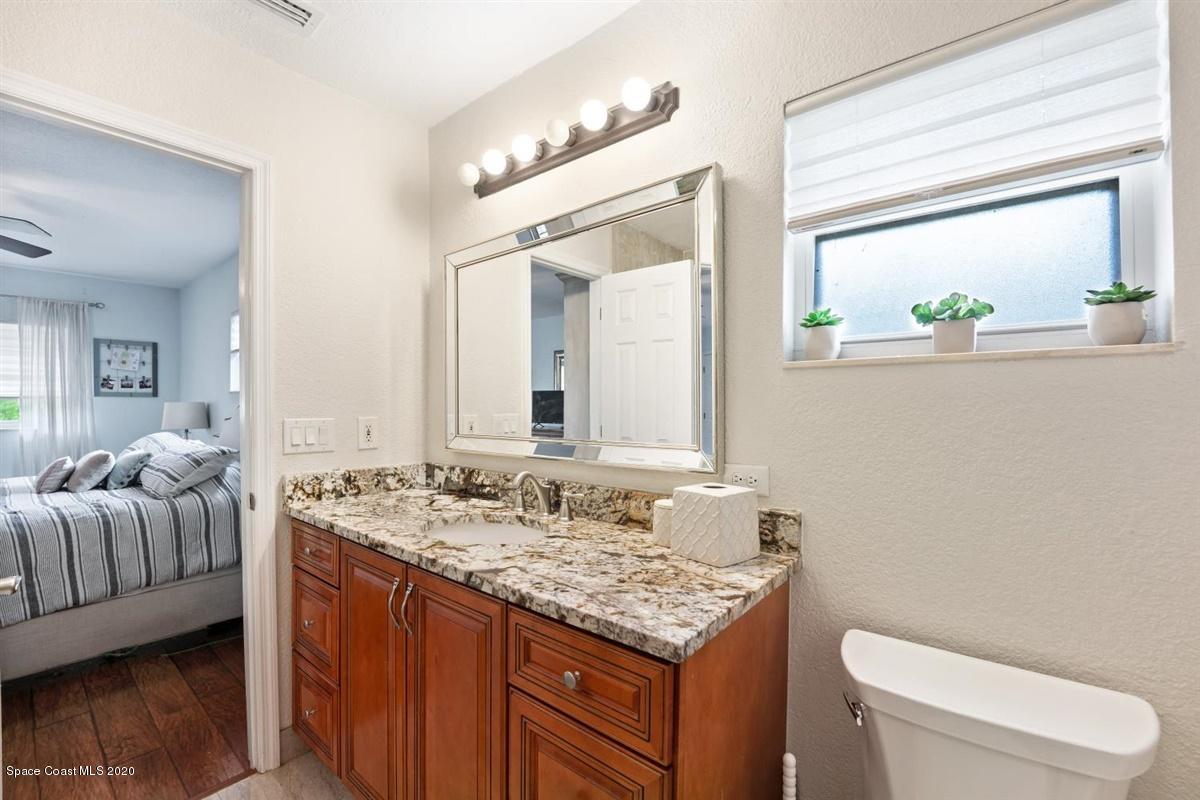 108 Neptune Court Indialantic, FL 32903 - Photo 26 of 33 a bathroom with a granite countertop sink and a toilet